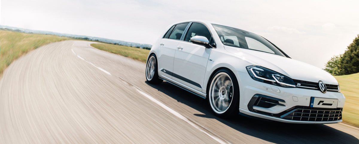 White Volkswagen Golf R driving on a country road – Marsanic Motorsport performance car parts